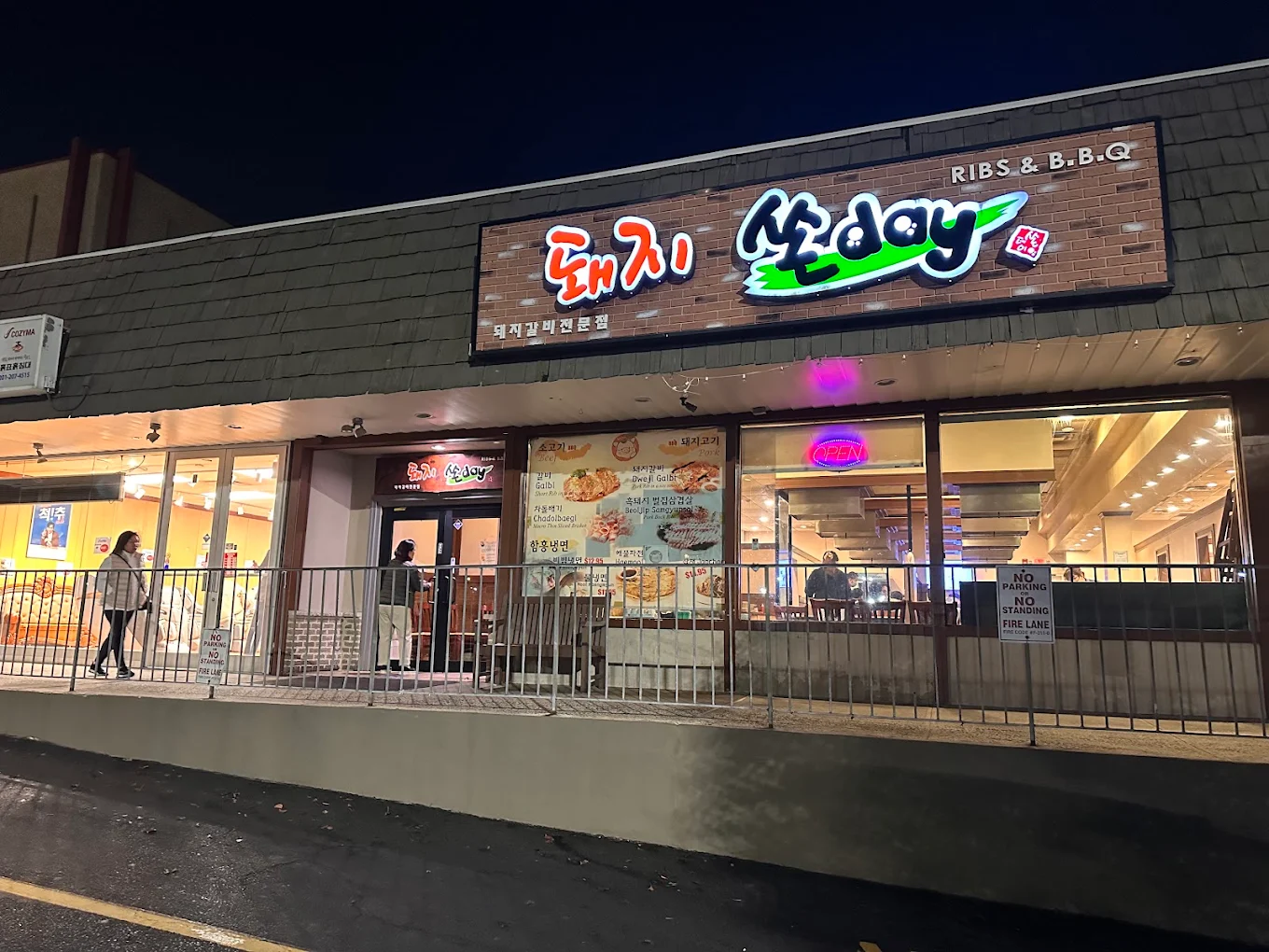 Piggy Ssonday storefront at night with its illuminated 돼지쏜day sign on Broad Ave